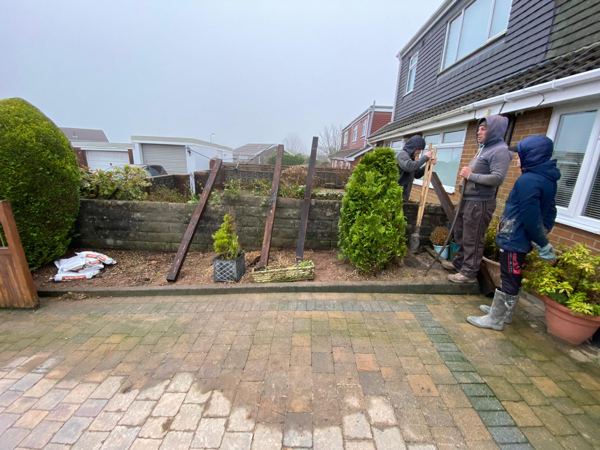 Before: a low wall and leaning posts, with the team starting work