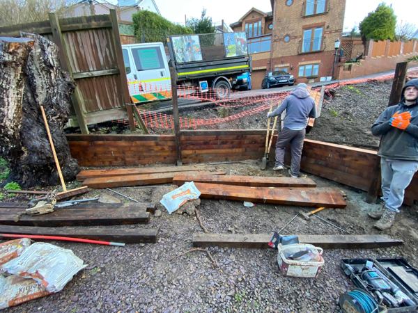 Building a sleeper retaining wall between timber posts on the lower slope