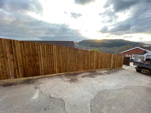 Close-board fence from the lane, looking out over the valley at sunset