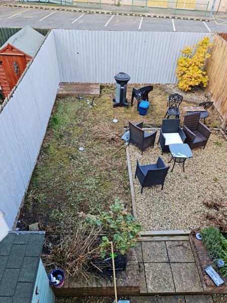 Before: a mossy, patchy lawn beside the gravel seating area, seen from upstairs