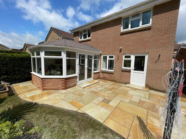 The finished golden sandstone patio wrapping round the conservatory
