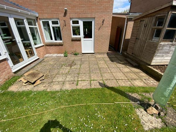 Before: stained and weedy concrete slabs behind the house