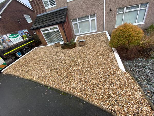 Before: loose golden gravel with white edging boards across the front garden