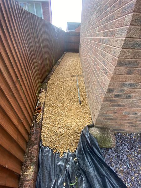 Golden gravel path laid over membrane down the narrow side passage