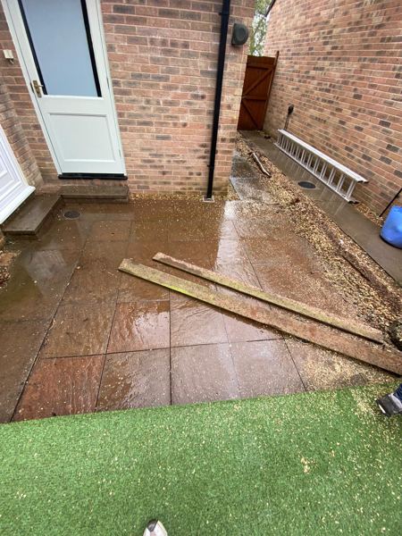 Wet slabs by a back door, with timber and a ladder still on site