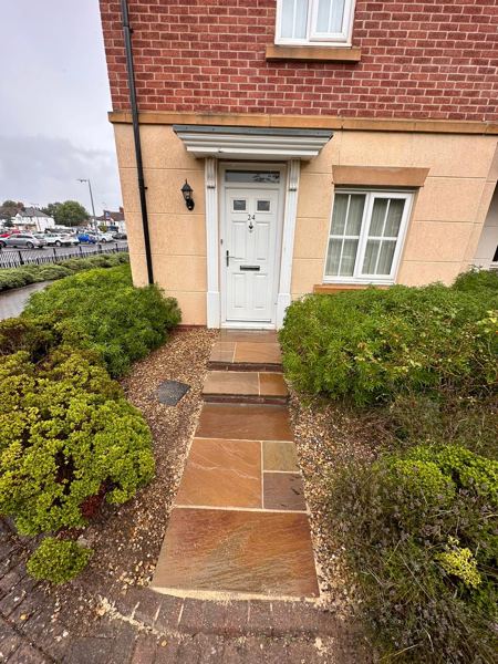 The finished sandstone front path and steps leading up to the white front door