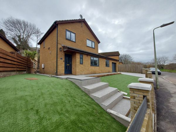 New front steps rising through the artificial lawn to the front door