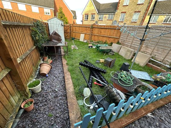Before: sleeper-edged lawn, slate chippings, picket fence and garden clutter