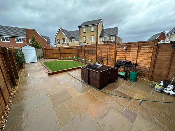 The finished garden: buff sandstone patio, raised grass area and gravel edges
