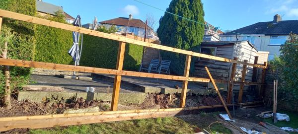 New timber posts and rails in place, with a prop bracing one post