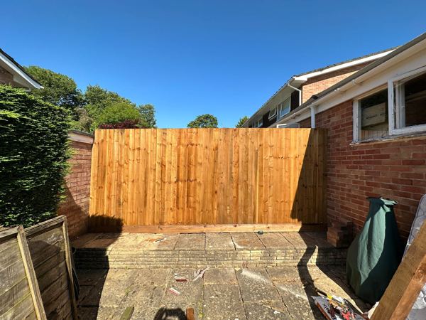 Close-board section closing the gap on a raised paved terrace by the house