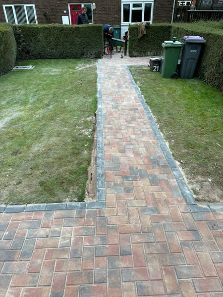The finished herringbone path running up between the lawns to the front door