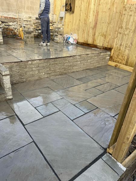 The raised patio level edged with a split-face walling retaining wall