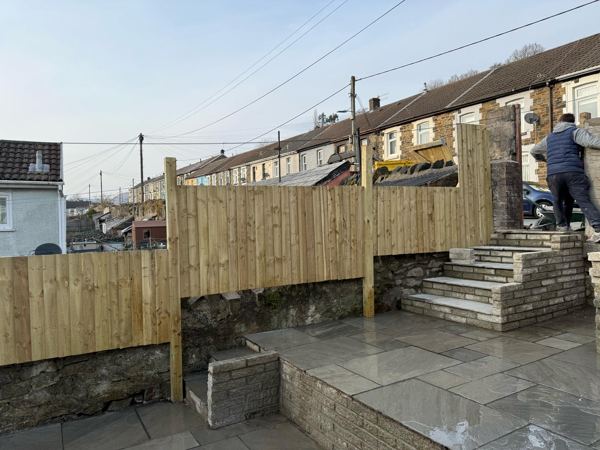 New timber fencing above the old stone walls, with steps up towards the lane