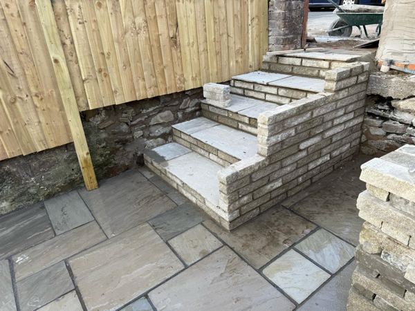New steps with slab treads and pale walled sides, linking two patio levels