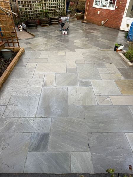 Wide view of the new paving, with pointing still under way at the back