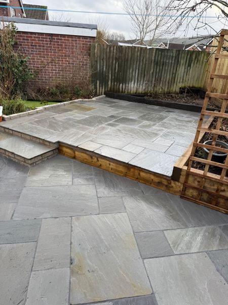 Sleeper-edged upper level with a slab step leading up from the patio