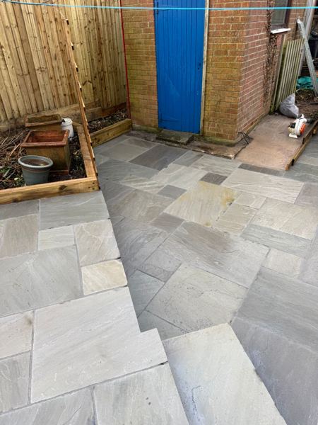 Paving running to the brick outbuilding, past a sleeper raised bed