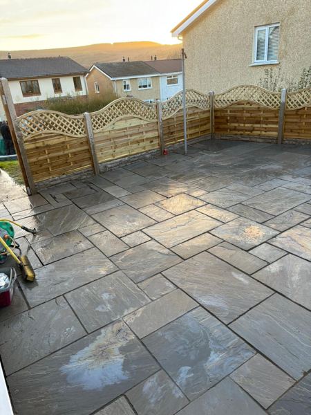 Freshly washed grey sandstone with arched trellis fencing and hills in the distance