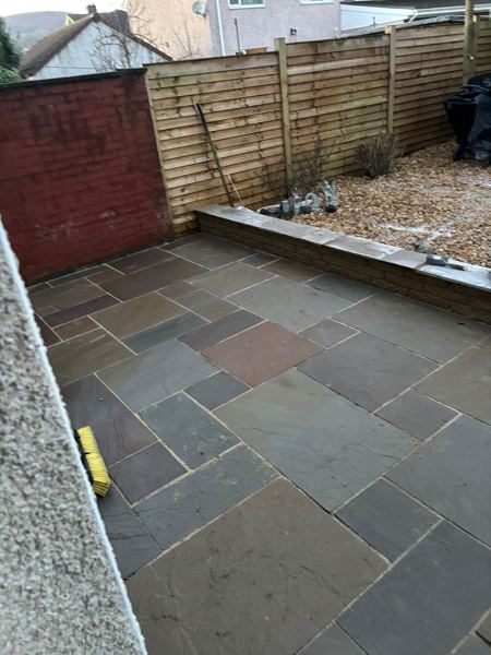 Looking down the patio from the house corner towards the horizontal slatted fence