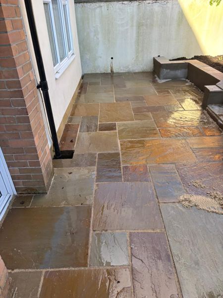 Wet sandstone in the back yard, running up to the raised bed