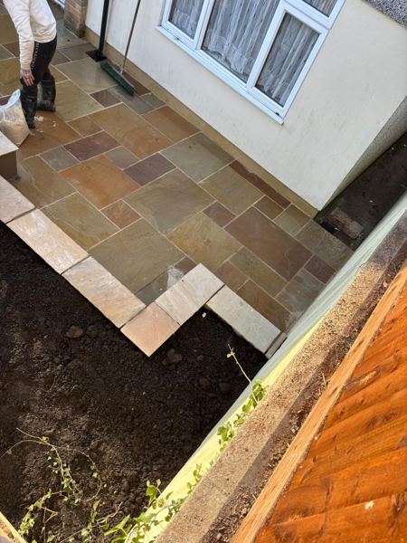 Looking down on the sandstone paving and slab edging beside a soil bed